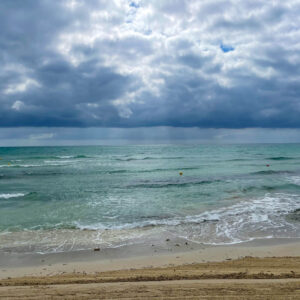 Dramatischer Strandblick: Bewölkter Himmel über dem Meer