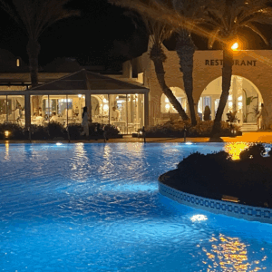 Restaurant mit beleuchtetem Pool bei Nacht