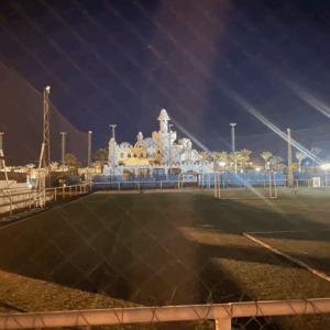 Beleuchtetes Schloss mit Sportplatz bei Nacht