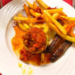 Gemischter Teller mit Pommes, Würstchen und Gemüse mit Tomatensauce