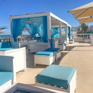Strandterrasse mit weißen Möbeln und blauem Himmel