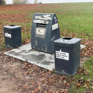 Müllstation mit humorvollen Aufklebern